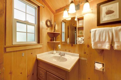 une salle de bain avec un lavabo et un miroir dans l'établissement Vintage Snow White Cottage about 2 Miles to Village!, à Lake Arrowhead