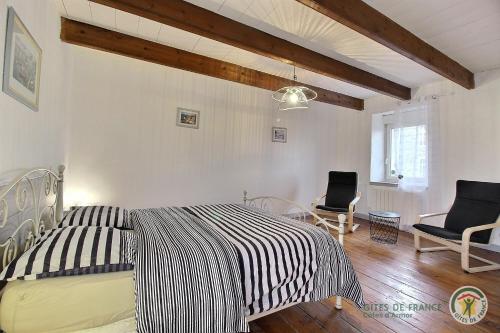 a bedroom with a black and white bed and two chairs at Ti coz in Lézardrieux