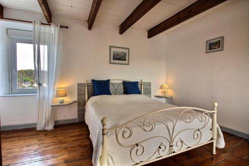 a bedroom with a bed with blue pillows and a window at Ti coz in Lézardrieux