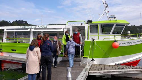 a group of people getting on a green and white boat at Ti coz in Lézardrieux