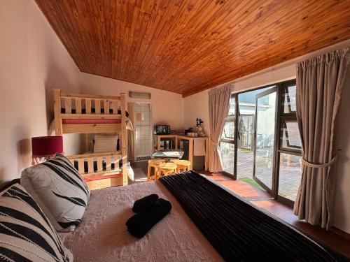 a living room with a bed and a large window at Sleeping Flamingo Guest House in Swakopmund