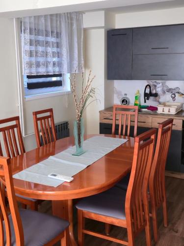 a dining room table and chairs with a table and a kitchen at Apartman Golubica in Vukovar