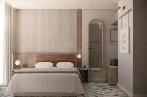 a bedroom with a large bed and a mirror at Dorsett Hotel Canary Wharf in London