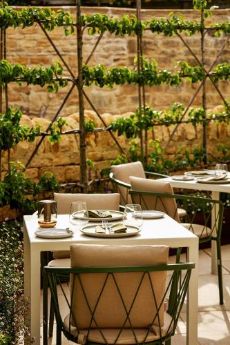 two tables and chairs with wine glasses on them at House of George W Davies in Broadway