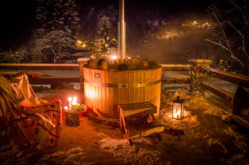 a wooden barrel with candles in the snow at night at Tre Alberi Liberi in Alagna Valsesia