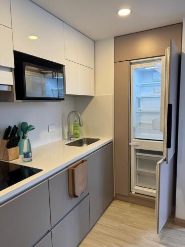 eine kleine Küche mit Spüle und Kühlschrank in der Unterkunft Bogotá Centro, Cerca de Monserrate y La Candelaria, Apartamento Moderno con Terraza panorámica, 2 habitaciones in Bogotá