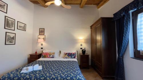 a bedroom with a bed with a blue comforter at Agriturismo La Casa Del Ghiro in Pimonte