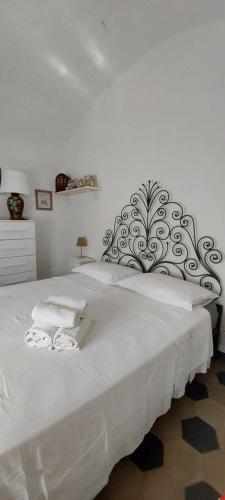 a bedroom with a white bed with two towels on it at Ca du Len Gorra - MTB's Friendly in Finale Ligure