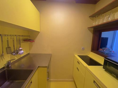 a yellow kitchen with a sink and a window at Appartme Nuova 52 in Milan