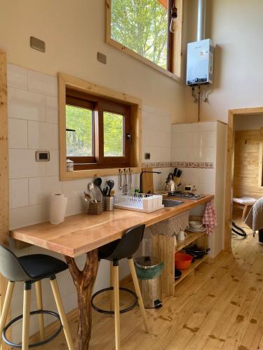 a kitchen with a wooden table and two bar stools at Mini Casa a 6 kilómetros de Villa Cerro Castillo Aysen Carretera Austral in Villa Cerro Castillo