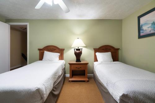 a room with two beds and a lamp in it at Mountain Meadows in Pigeon Forge