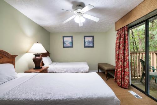 a hotel room with two beds and a ceiling fan at Mountain Meadows in Pigeon Forge