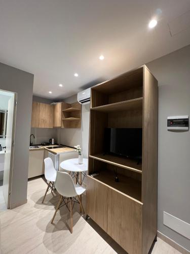 a kitchen and living room with a tv and a table at Vila Serenita in Vlorë