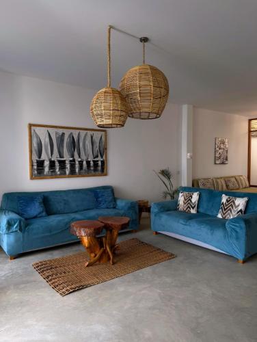 a living room with a blue couch and a table at Gaia - Casa de Playa in Canoas de Punta Sal