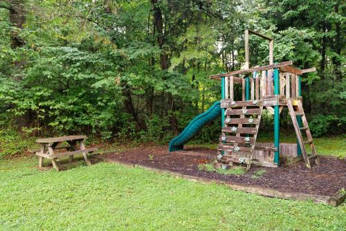 a park with a playground with a slide and a bench at Mountain Meadows in Pigeon Forge