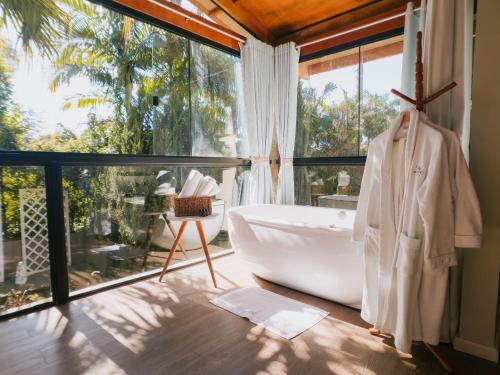 a bathroom with a tub and a large window at Hotel Sonnet Curitiba in Curitiba