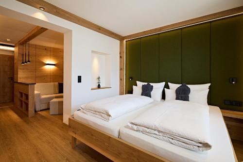 a bedroom with a large bed with a green headboard at Hotel Rosenstock - Erwachsenenhotel - Adults only 15 plus in Fischen