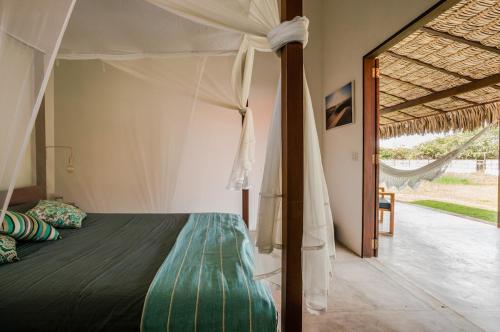 a bedroom with a bed with a canopy at Villa Estrelas Atins in Atins
