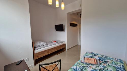 a small bedroom with a bed and a chair at Bos-Znam Pokoje in Gdynia