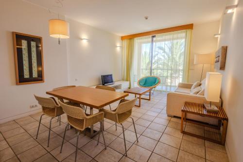 a living room with a table and chairs and a couch at The Navigator - Colombus Apartments & Villas in Porto Santo