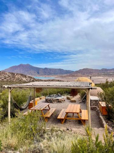 a picnic table in the desert with mountains in the background at El Nido Domos in Mendoza