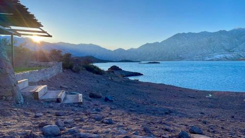 a bench on a beach near a body of water at El Nido Domos in Mendoza