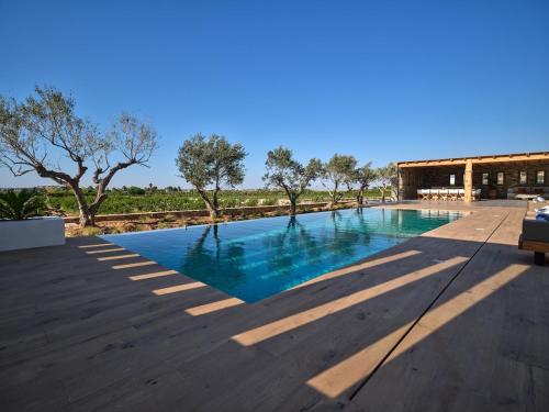a swimming pool with blue water on a wooden deck at Villa Zamira in Isterni