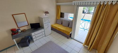a bedroom with a desk and a bed and a window at Studio CRISTAL COCO Martinique in Les Trois-Îlets