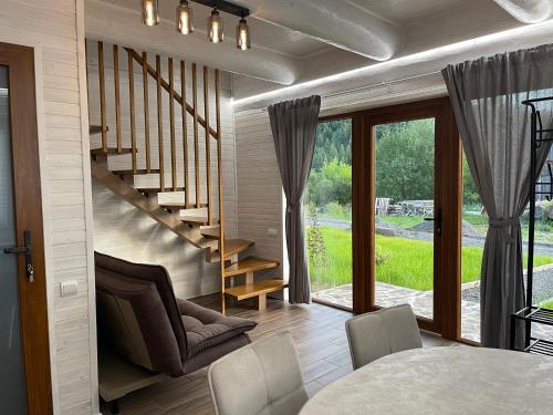 a living room with a staircase and a table and chairs at Еко будинок Duet in Maydan