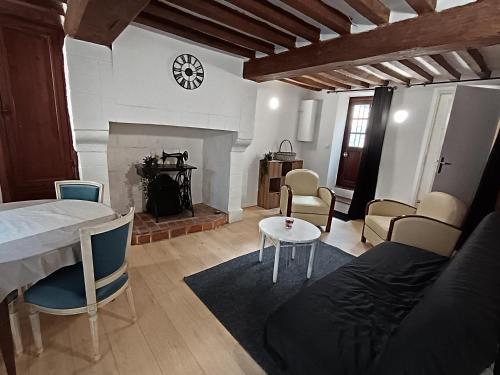 a living room with a bed and a fireplace at Le studio Aristide in Pont-Audemer