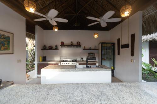 a kitchen with two ceiling fans and a stove at Oceanfront Casa Rhino in Paso Hondo