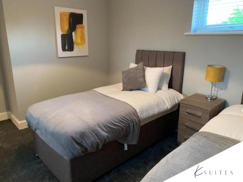 a bedroom with two beds and a lamp on a night stand at K Suites - The Galleria in Hatfield