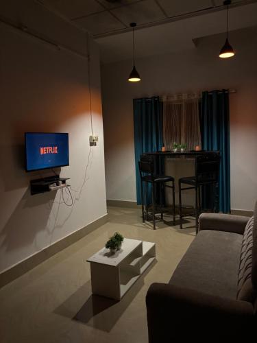Una sala de estar con un televisor y una mesa. en Zest home, en Jorhat
