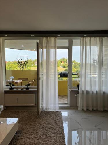 un salon avec portes coulissantes en verre et vue dans l'établissement Gemütliche Ferienwohnung 479 im Panoramic Hohegeiß Braunlage mit Pool und Sauna, à Braunlage