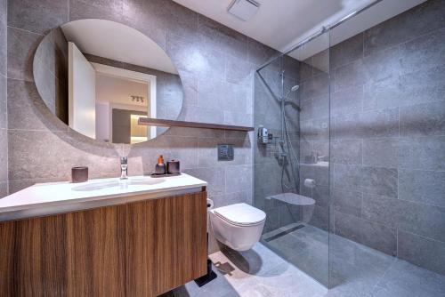 Un baño con inodoro, lavabo y espejo. en Belgrade Waterfront Ana Premium Living, en Belgrado