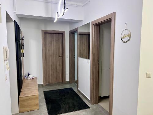 a hallway with wooden doors and a rug at Biby Luxury Apartament in Ploieşti