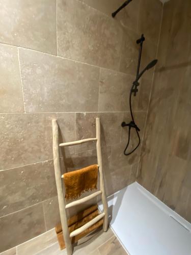 a bathroom with a wooden chair in a shower at Joli mas bohème 60 m carré a seulement une minute à pied de la plage 4 personnes in Le Pradet