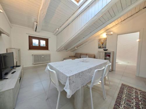 a dining room with a white table and chairs at Hostdomus - Stella Alpina in Pragelato