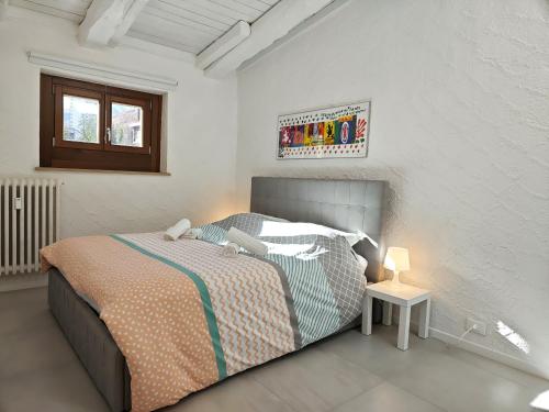 a bedroom with a bed in a white room at Hostdomus - Stella Alpina in Pragelato