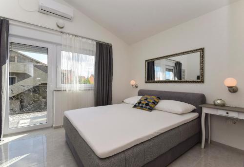 een slaapkamer met een bed met een spiegel en een raam bij Mary Rose in Vodice