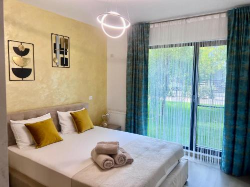 a bedroom with a bed with a large window at Biby Luxury Apartament in Ploieşti
