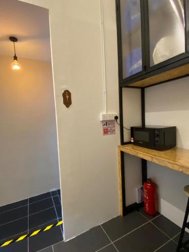 ジョージタウンにあるAmore Stayの電子レンジとカウンターのあるキッチンへのドア