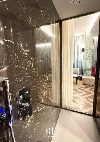 a bathroom with a black marble wall at Iris Hotel in Erbusco
