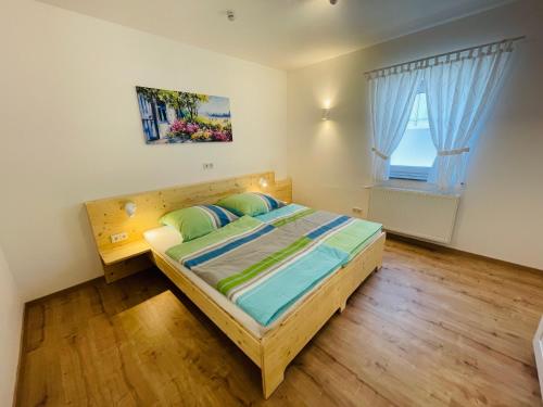 a bedroom with a wooden bed and a window at Ferienwohnung Bad Camberg - Apartment Baumwipfel in Bad Camberg