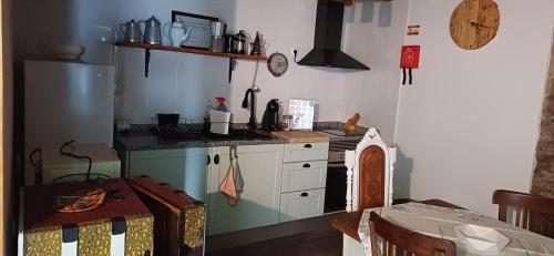 a kitchen with a stove and a table in it at Casa ASCARIUS in Escarigo