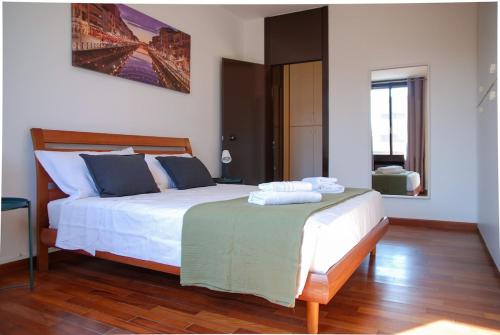 a bedroom with a white bed with a green blanket on it at Home & Pet - Tralci in Basiglio