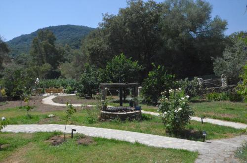 a garden with a fire pit in the middle at Habitación jardín junto al río in El Colmenar