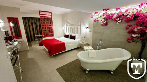 a bedroom with a bed and a bath tub in a room at Hotel La Residence Hammamet in Hammamet