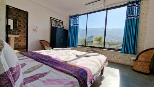 a bedroom with a bed and a large window at Café The Wall in Pushkar