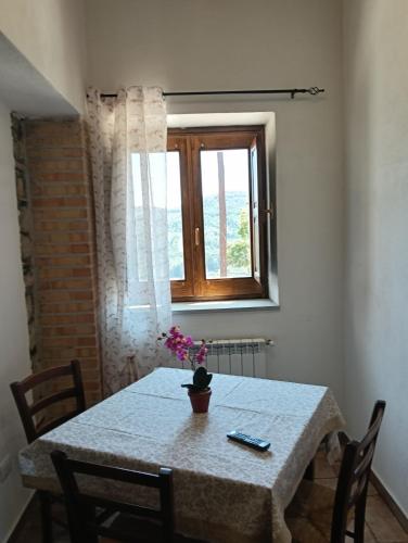 a table with a vase of flowers on it at Lodge Il Capitano in San Piero Patti